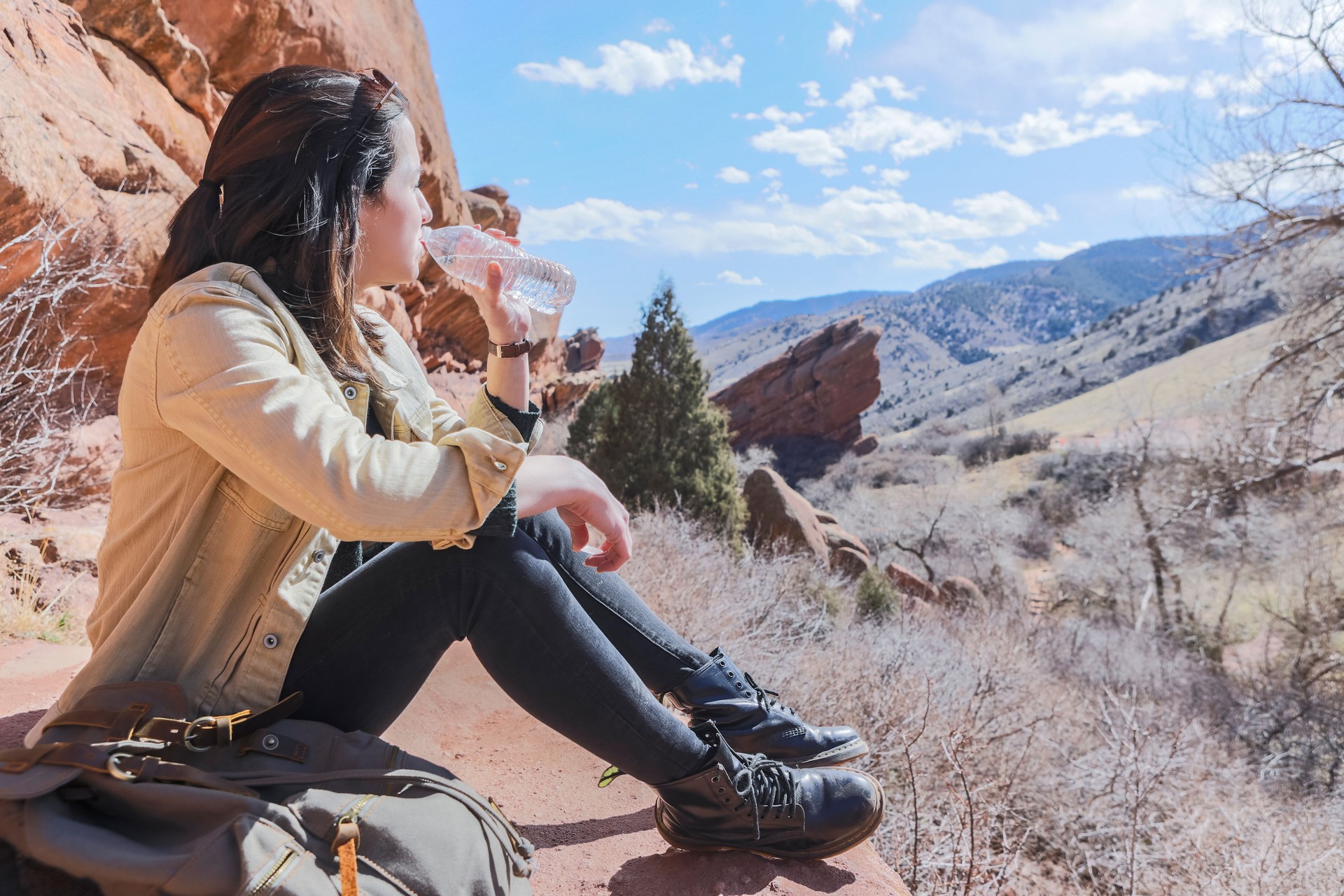Unrecognizable woman takes hiking water break in canyon